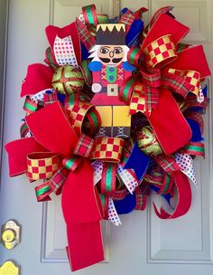 a red and green wreath with a nutcracker on it