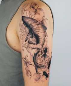 a man with a shark tattoo on his arm and shoulder is shown in black and grey