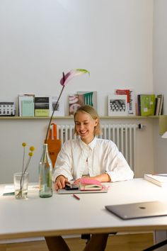 a woman sitting at a table in front of a book