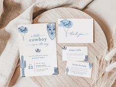 the wedding stationery is laid out on a wooden plate