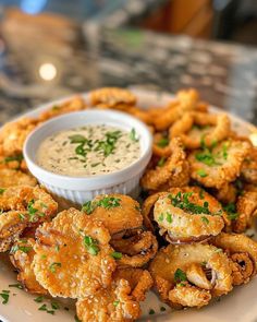 a plate full of fried food with dipping sauce