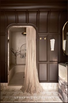 an open doorway leading to a bathroom with marble flooring and walls in dark brown tones