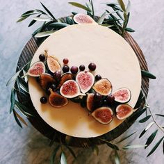 a cake with figs and olives on it sitting on top of a table