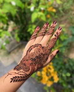 a woman's hand with hennap on it and flowers in the background