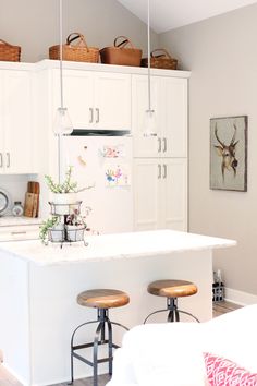 a kitchen with white cabinets and stools