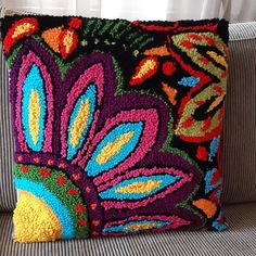 a colorful pillow is sitting on a couch