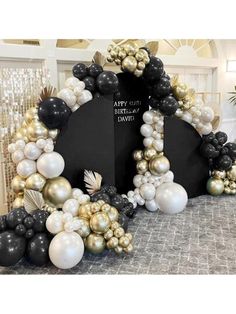 a black and white arch with balloons on the front, gold and silver decorations around it