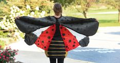 a ladybug costume is being carried by a woman in black and red dress