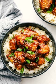 two bowls filled with rice and meat covered in sauce