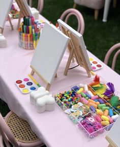 the table is set up with art supplies for children to paint and draw on it