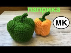 two crocheted pumpkins sitting on top of a table next to each other