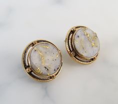 "The simple 14k yellow gold bezel-settings showcase the round gold-in-quartz stones within these antique 1910s earrings. Black enamel rings and textured spheres frame the stones nicely. Gold-Bearing Quartz is one of the world's rarest forms of natural gold. It is found underground by hard rock miners in only a few locations in the world. The natural veins of pure gold were formed in quartz by hydrothermal pressure deep within the earth millions of years ago. The flat polished gems are of white t Luxury Round Cabochon Clip-on Earrings, Formal Oval Earrings With Bezel Setting, Formal Oval Bezel Set Earrings, Antique Yellow Gold Clip-on Earrings For Formal Events, Antique Yellow Gold Clip-on Earrings For Formal Occasions, Formal Yellow Gold Gemstone Clip-on Earrings, Art Deco Clip-on Jewelry For Formal Occasions, Clip-on Art Deco Jewelry For Formal Occasions, Formal Art Deco Clip-on Jewelry