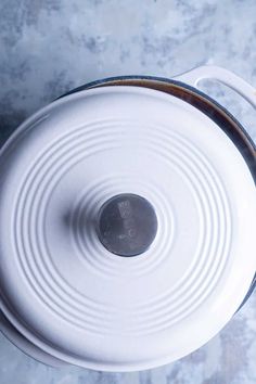 a white pot with a lid sitting on top of a table