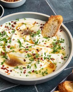 a bowl of food with bread on the side