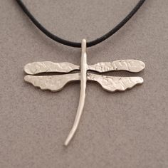 "Attract all the right attention with this dragonfly pendant, made of sterling silver 925. Hangs on 42 cm cord (16 1/2\") with silver clasp and endings. A hammered piece, perfectly conveys the exquisite, organic beauty found in nature. Pendant measures 3.5 cm x 2.7 cm (1.38 inches x 1.06 inches) Metal: Sterling silver 925, slightly oxidized for a more vivid look. If you want a different cord length, write us the desirable length to the \"note to the seller\" during the checkout process. If you p Adjustable Sterling Silver Dragonfly Necklace, Dragonfly Jewelry Necklace, Silver Dragonfly Necklace, Dragonfly Jewelry, Dragonfly Necklace, Dragonfly Pendant, Dec 7, Organic Beauty, Jewelry Necklace