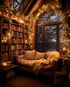 a room with a couch, bookshelf and christmas lights on the windowsill