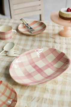 pink and white checkered dishes on a table with utensils