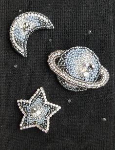 three pieces of sequinized fabric with stars and planets