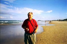 an older man is standing on the beach