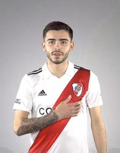 a man holding a red and white soccer jersey