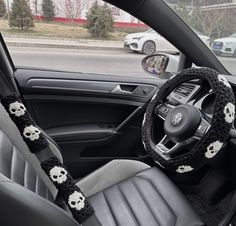 the interior of a car decorated with skulls and crocheted steering wheel corsage