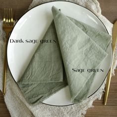 two napkins sitting on top of a white plate next to a fork and knife