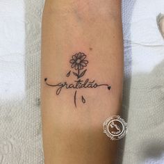 a tattoo with the word gratilla written in cursive writing and a flower