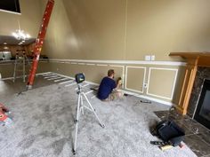 a man sitting on the floor in front of a fire place next to a ladder