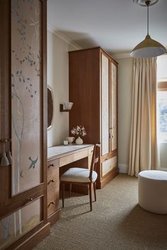 a bedroom with a bed, desk and chair in front of a window that has curtains on the windowsill