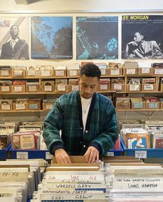 a man standing in front of a table filled with records