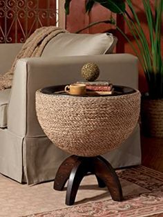 a living room with a couch, chair and coffee table in front of a potted plant