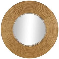 a round mirror on a white wall with a wooden frame and wood grain pattern around it