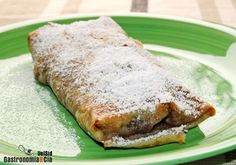 a green plate topped with a pastry covered in powdered sugar