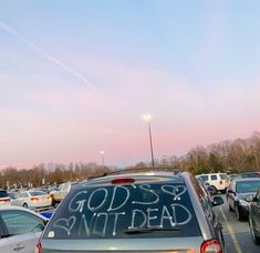 cars parked in a parking lot with writing on the windshield