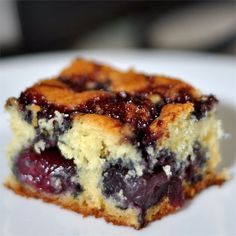 a piece of blueberry cheesecake on a white plate with a bite taken out