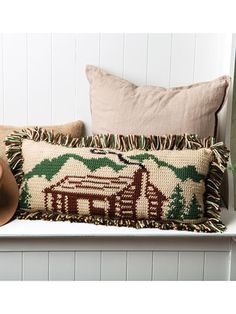 a couple of pillows sitting on top of a white shelf next to a cowboy hat