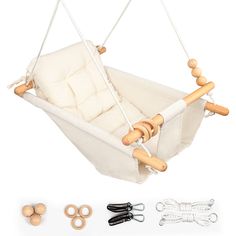 a white baby swing with wooden handles and two pairs of black scissors next to it