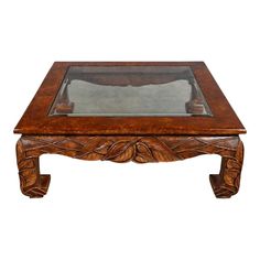 a wooden coffee table with glass top and carved design on the bottom, against a white background