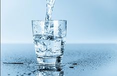 a glass filled with water sitting on top of a table