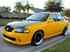 the yellow car is parked on the side of the road