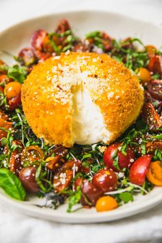 a white plate topped with a salad covered in cheese