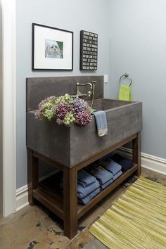 a bathroom sink sitting under a mirror next to a rug and pictures on the wall