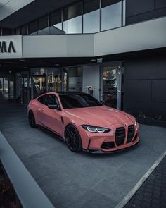 a pink car parked in front of a building