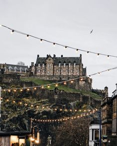 an old castle on top of a hill with string lights strung from it's sides