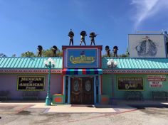 the mexican american bar is painted bright blue and has statues on it's roof