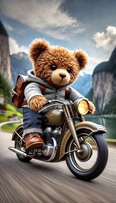 a brown teddy bear riding on the back of a motorcycle in front of some mountains