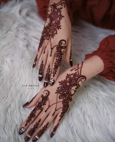 a woman's hand with henna tattoos on it, and her hands are decorated with