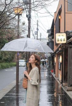 a woman holding an umbrella in the rain