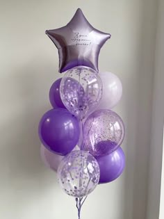 purple and white balloons are arranged in the shape of a star