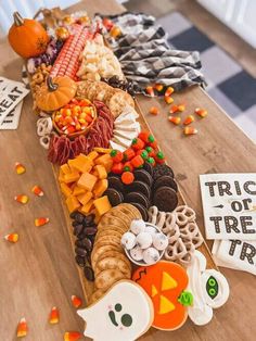 a wooden table topped with lots of candy and candies next to a sign that says trick or treat train